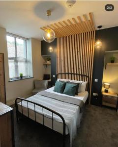 a bedroom with a large bed with blue pillows at Mansel House - Sleeps 14 - By TIFA Stays in Swansea +12 photos