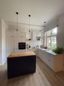 a kitchen with white cabinets and a black island in it at Przestronne mieszkanie w kamienicy in Gdańsk