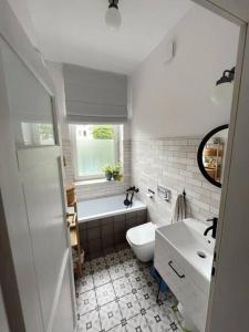 a bathroom with a toilet and a tub and a sink at Przestronne mieszkanie w kamienicy in Gdańsk