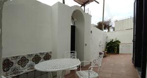 a patio with a table and chairs on a balcony at La Romantique in Anacapri
