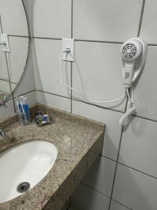 y baño con lavamanos y secador de pelo. en Gran Lençóis Flat Residence Apartamento Atins 109 en Barreirinhas