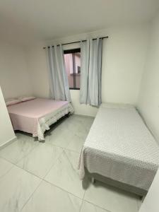 two beds in a room with a window at Casa em Santa Teresa-ES in Santa Teresa