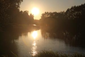 une rivière avec le soleil réfléchissant sur l'eau dans l'établissement Krastmslas, à Smaltāni