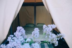 Smaltāni的住宿－Krastmslas，一间卧室,床上有紫色鲜花