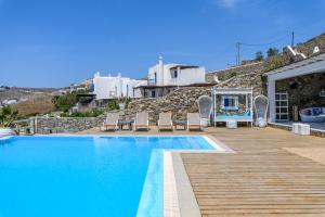 a swimming pool with chairs next to a house at Salty Blè in Agios Ioannis Mykonos