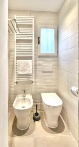 ein Badezimmer mit einem weißen WC und einem Waschbecken in der Unterkunft Casa Clementina in Pisa