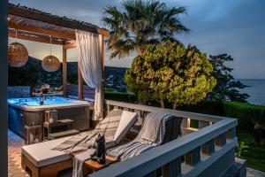 a balcony with a bath tub and a table and chairs at Everest Apartments and Suites in Stalida