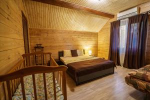 ein Schlafzimmer mit einem Bett in einer Holzhütte in der Unterkunft Dacha 9 in Voropayev
