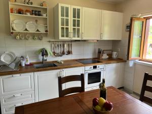 una cucina con armadi bianchi e tavolo in legno di Mountain House Paula a Baške Oštarije