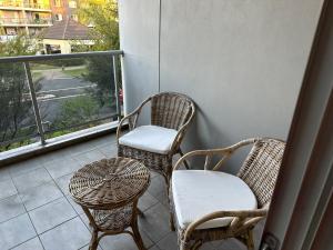d'un balcon avec deux chaises, deux tables et une fenêtre. dans l'établissement Westmead Home away from home, à Westmead