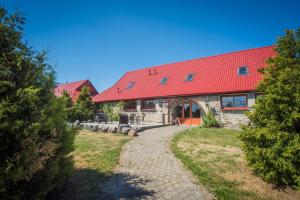 a building with a red roof and a pathway at Teeristi villa in Paslepa