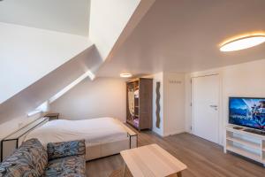 Schlafzimmer mit einem Bett und einem TV in der Unterkunft M&F Sweet In Grey in Vilvoorde