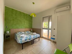 a bedroom with a bed and a green wall at Lu Jentu in Torre Ovo