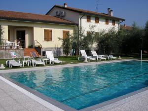 a swimming pool with chairs and a house at Agriturismo Ca' Licante in Bardolino
