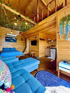 ein Wohnzimmer mit blauen Sofas und einem TV in der Unterkunft Manzara dağevi in Rize