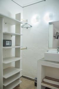 a white bathroom with a sink and a mirror at Hotel Beach Energy 5th Av in Playa del Carmen