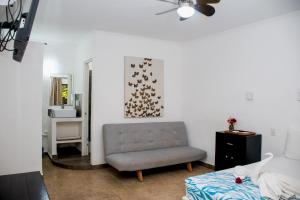 a living room with a couch and a chair at Hotel Beach Energy 5th Av in Playa del Carmen
