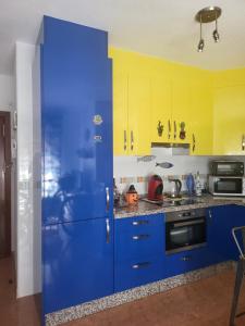 a blue refrigerator in a kitchen with yellow cabinets at Apartamento La Urba in Roquetas de Mar