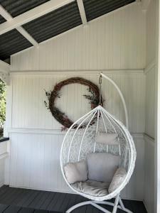 a white swinging chair in a porch with a wreath at Gorgeous Arthouse Queenslander In Ipswich in Bundamba