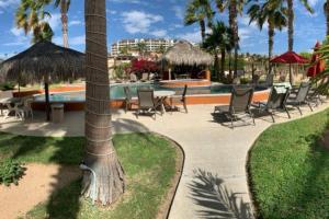 a resort with a pool and chairs and a palm tree at 2Bdr Hidden Gem Condo w/ Pool in San José del Cabo