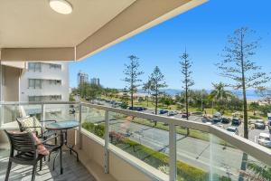 a balcony with a table and chairs and a view of a city at Kooringal Unit 10 in Gold Coast