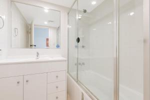a white bathroom with a shower and a sink at Kooringal Unit 10 in Gold Coast +6 photos