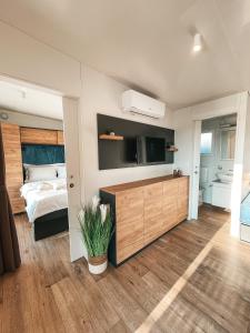 a bedroom with a bed and a flat screen tv at SEAYA mobile home - Terra Park SpiritoS in Kolan