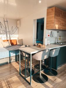 a kitchen and living room with a table and chairs at SEAYA mobile home - Terra Park SpiritoS in Kolan