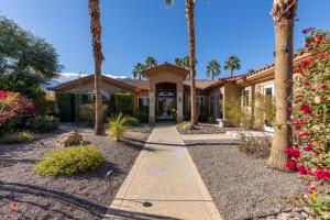 een huis met palmbomen en een loopbrug bij Mon Cheri Estate in Palm Springs