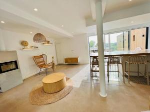 a large living room with a table and a kitchen at Les volets bleus in Saint-Venant