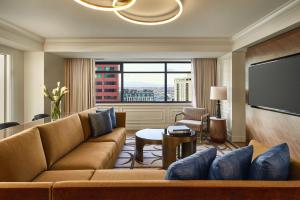 a living room with a couch and a flat screen tv at The Ritz-Carlton, Denver in Denver