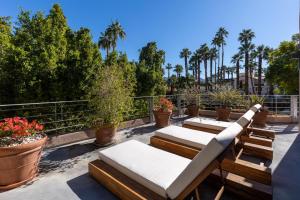 um pátio com espreguiçadeiras e vasos de plantas em Camino Mountain Villa em Palm Springs