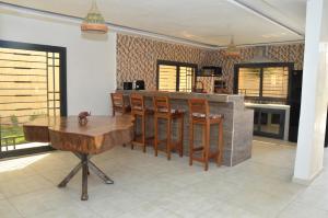 a kitchen with a wooden table and chairs at Keur Méry in Ngaparou