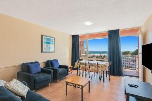 Una sala de estar con un sofá y sillas y una mesa. en Beach Lodge Unit 9, en Gold Coast 5 fotos más