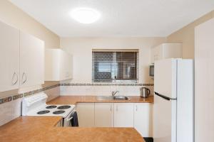 a kitchen with white appliances and a white refrigerator at Beach Lodge Unit 9 in Gold Coast