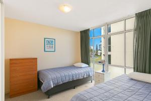 Un dormitorio con dos camas y una ventana. en Beach Lodge Unit 9, en Gold Coast