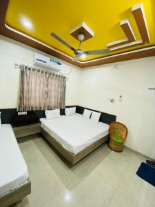 1 dormitorio con cama blanca y techo amarillo en SARDAR HOME STAY, en Garudeshwar