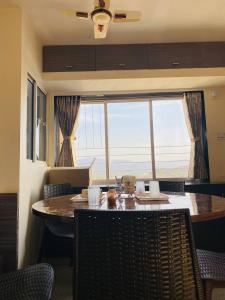a dining room with a table and a large window at SARDAR HOME STAY in Garudeshwar
