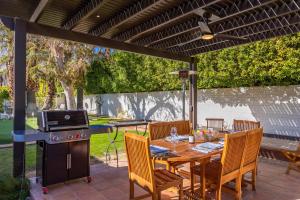 a patio with a table and a grill and a table and chairs at Lola Vista in Palm Springs