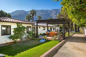 a house with a yard with grass and mountains at Lola Vista in Palm Springs