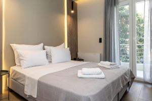 a bedroom with a large white bed with towels on it at 8 Blocks Apartments 4A in Alexandroupoli