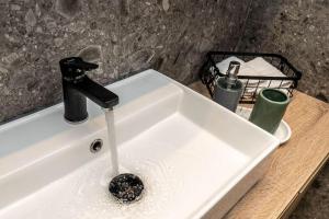 a sink with water running from a faucet at 8 Blocks Apartments 4A in Alexandroupoli