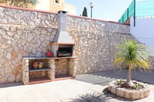 eine Steinmauer mit einem Pizzaofen neben einem Baum in der Unterkunft Luxury Villa with ocean view in Luz