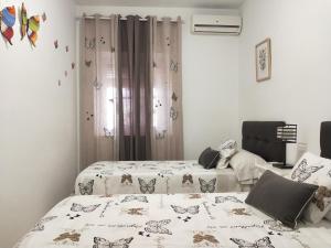 two beds in a room with butterflies on them at Acogedora casa cerca de Córdoba in Encinarejo De Córdoba +23 photos