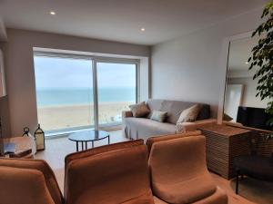 uma sala de estar com um sofá e vista para o oceano em Appart Noah SeaFront em Knokke-Heist