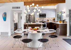 a kitchen with a large white table and chairs at Mid Century Mood House in Palm Springs