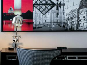 a desk with a lamp and a picture on the wall at Sofitel Lafayette Square Washington DC in Washington