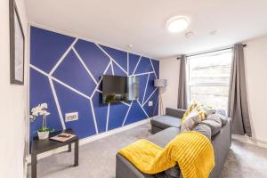 sala de estar con sofá y pared azul en Contractors, Families, FREE PARKING, Central - Print Place by Prescott Apartments en Bristol
