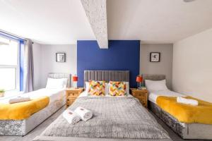 a bedroom with two beds and a blue wall at Contractors, Families, FREE PARKING, Central - Print Place by Prescott Apartments in Bristol