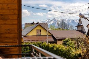 una casa amarilla con una montaña en el fondo en Czarna Góra Apartamenty TATRY GÓRY BIAŁKA BUKOWINA AGROTURYSTYKA, en Czarna Góra